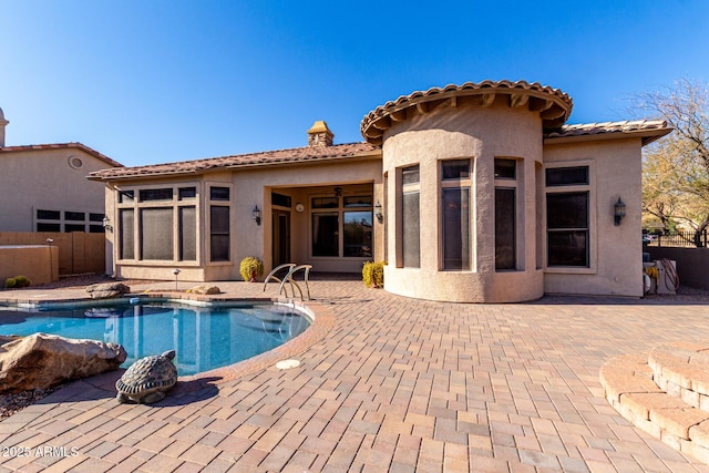 pool with a patio area, fence, and a ceiling fan