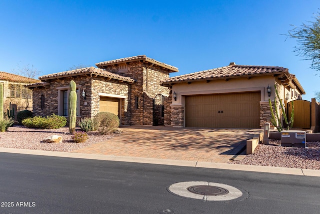 view of front of property featuring stone siding, a tiled roof, an attached garage, and stucco siding