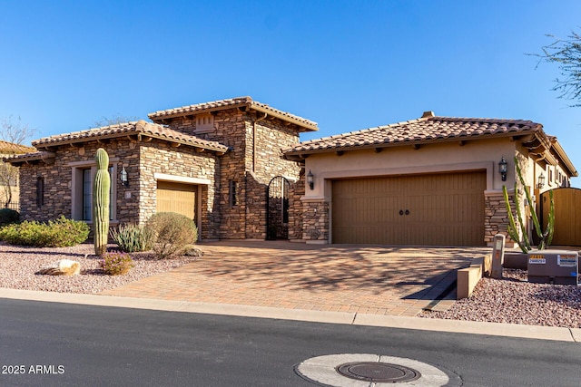 view of front of property with stone siding, a tile roof, and an attached garage