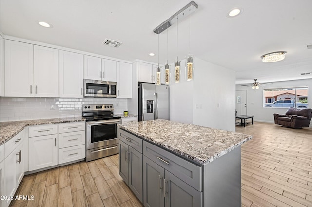 1017 S Allen, Mesa, AZ 85204 - kitchen featuring appliances with stainless steel finishes, open floor plan, tasteful backsplash, light wood-type flooring, and recessed lighting
