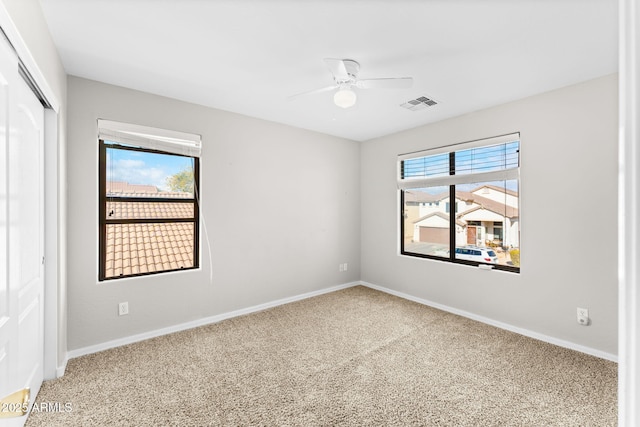 spare room with carpet floors and ceiling fan