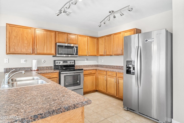 kitchen with light tile patterned flooring, stainless steel appliances, and sink