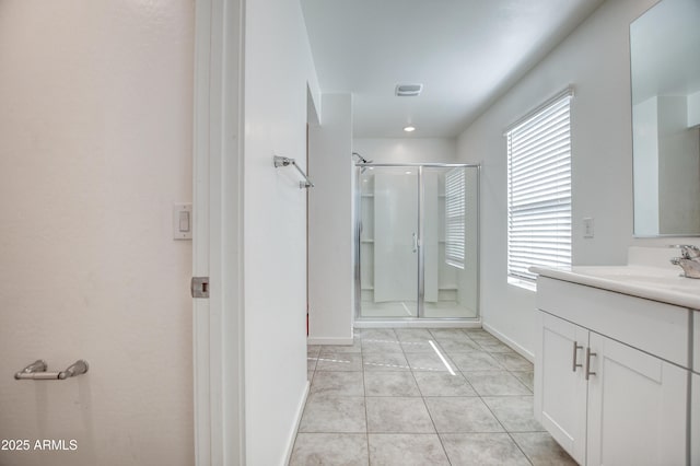 bathroom featuring tile patterned floors, vanity, and a shower with door