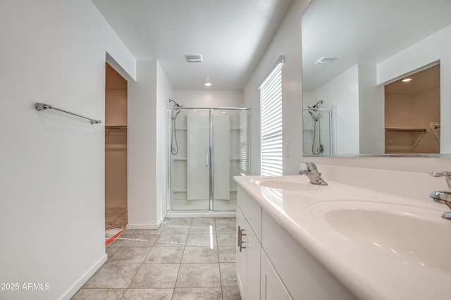 bathroom featuring tile patterned floors, a shower with shower door, and vanity