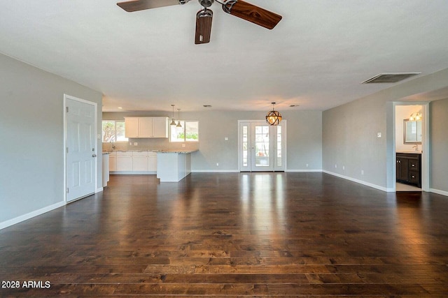 unfurnished living room featuring dark wood-style floors and a wealth of natural light