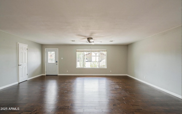 unfurnished room featuring dark wood-type flooring, visible vents, ceiling fan, and baseboards