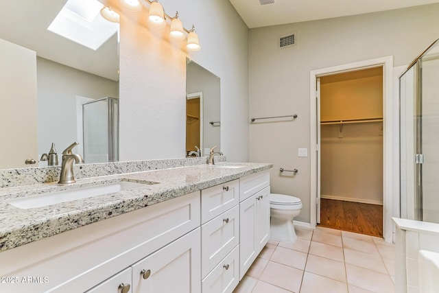 1048 N Arroya, Mesa, AZ 85205 - full bathroom featuring a skylight, a shower stall, double vanity, a spacious closet, and tile patterned floors