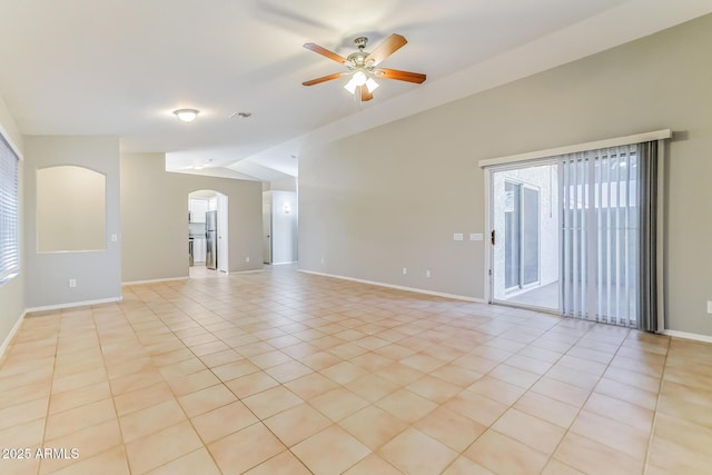 1048 N Arroya, Mesa, AZ 85205 - spare room with vaulted ceiling, arched walkways, ceiling fan, and light tile patterned flooring