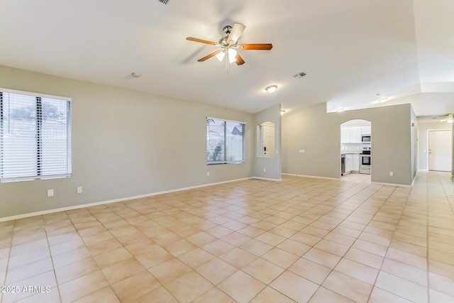 1048 N Arroya, Mesa, AZ 85205 - unfurnished living room featuring lofted ceiling, a ceiling fan, arched walkways, plenty of natural light, and light tile patterned floors