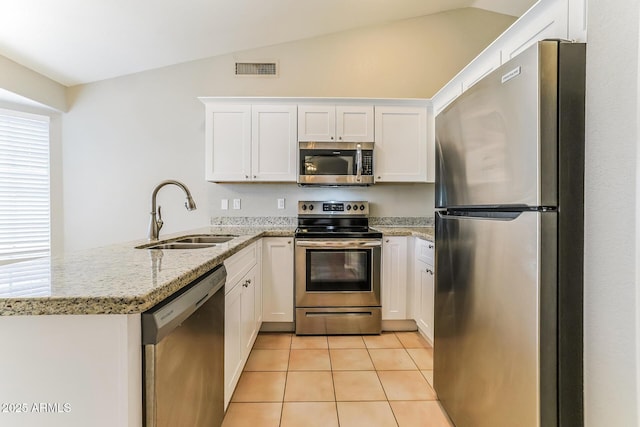 1048 N Arroya, Mesa, AZ 85205 - kitchen featuring stainless steel appliances, a peninsula, vaulted ceiling, light tile patterned floors, and white cabinets