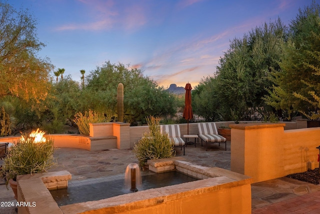 patio terrace at dusk featuring a fire pit