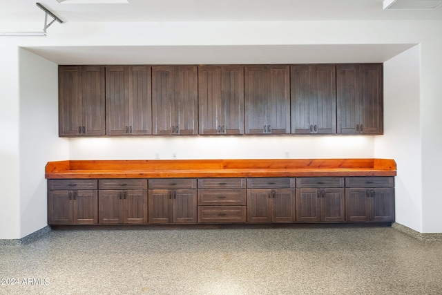 bar featuring wood counters and dark brown cabinets