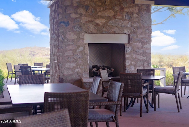 view of patio / terrace with a mountain view and an outdoor stone fireplace