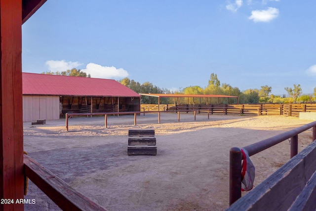 view of horse barn with a rural view