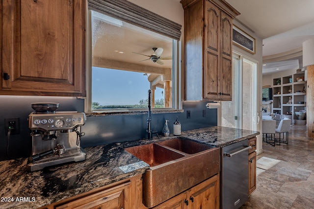 kitchen featuring dark stone countertops, ceiling fan, sink, and dishwasher