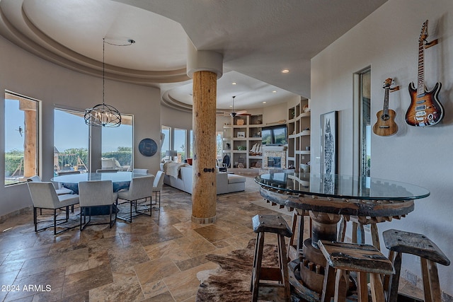 dining room featuring a notable chandelier, a tray ceiling, and built in features