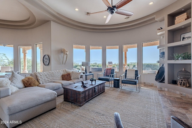 living room with ceiling fan and a towering ceiling