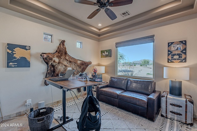 office space with ceiling fan and a raised ceiling