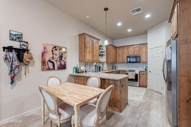 kitchen with light stone countertops, appliances with stainless steel finishes, sink, kitchen peninsula, and hanging light fixtures