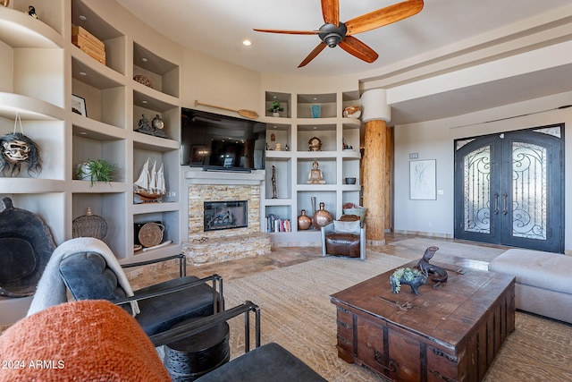 living room with french doors, a fireplace, built in shelves, and ceiling fan