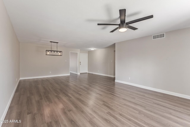 11671 S Jokake St, Phoenix, AZ 85044 - unfurnished living room featuring ceiling fan, wood finished floors, and baseboards