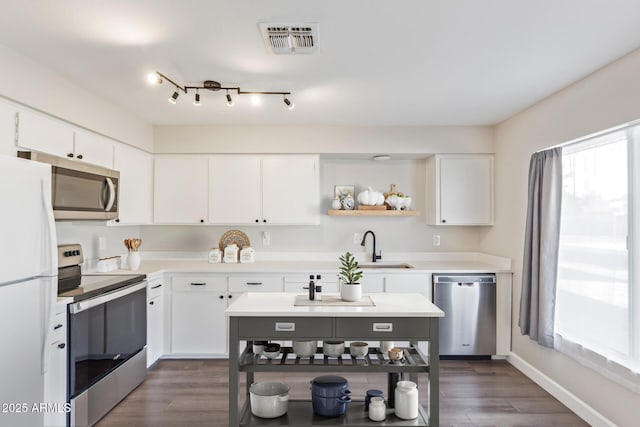 11671 S Jokake St, Phoenix, AZ 85044 - kitchen with appliances with stainless steel finishes, open shelves, white cabinets, and a sink