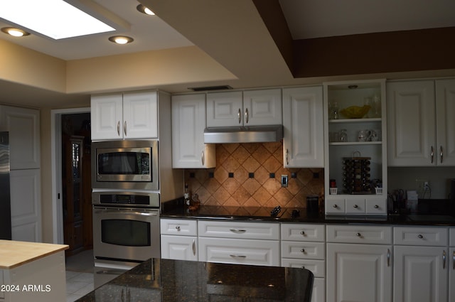 kitchen with tasteful backsplash, white cabinets, light tile patterned floors, and appliances with stainless steel finishes