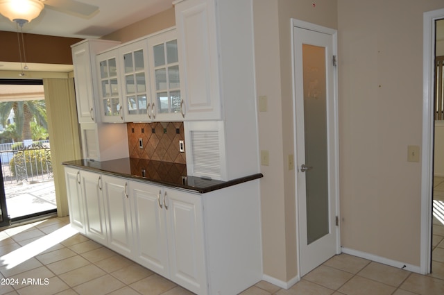 kitchen with white cabinets, ceiling fan, light tile patterned floors, and tasteful backsplash