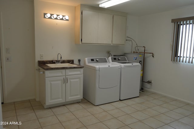 clothes washing area with cabinets, light tile patterned flooring, washing machine and dryer, and sink