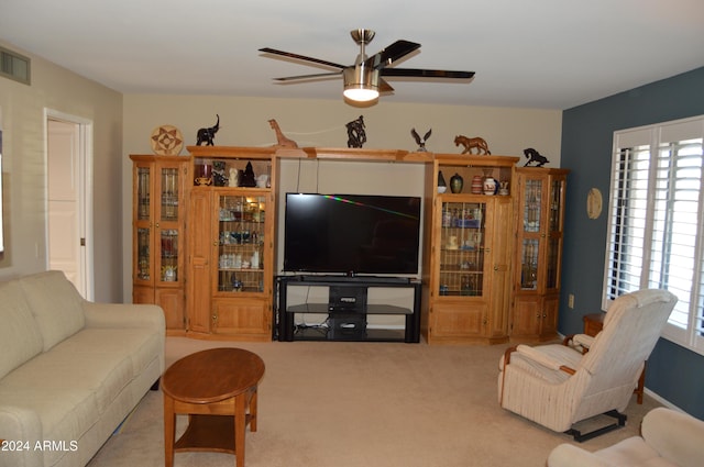 carpeted living room with ceiling fan