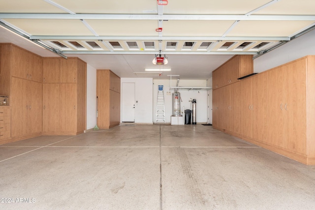 garage featuring water heater, wood walls, and a garage door opener