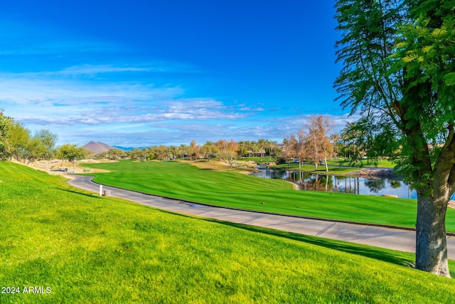 view of property's community with a water and mountain view and a yard