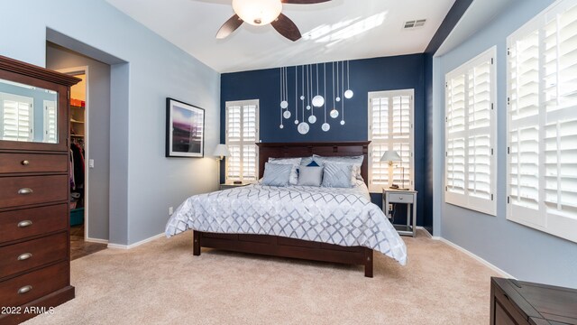 carpeted bedroom with multiple windows and ceiling fan