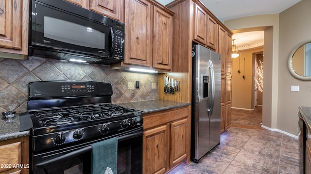 kitchen featuring decorative backsplash, black appliances, and dark stone countertops