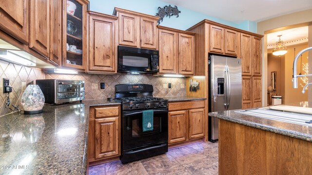 kitchen with black appliances, decorative backsplash, and dark stone countertops