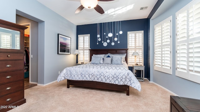 bedroom featuring light colored carpet and multiple windows