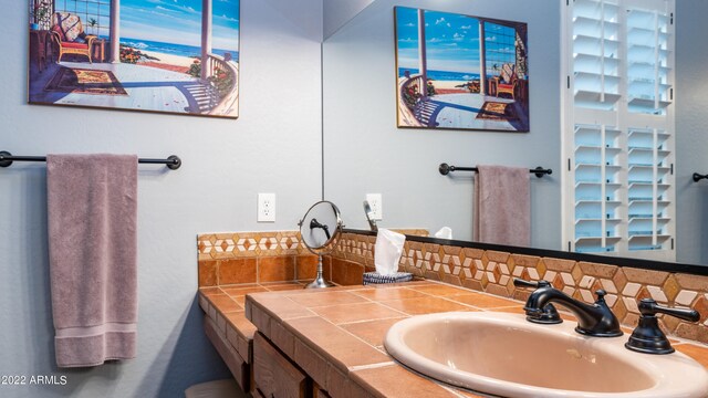 bathroom featuring vanity and backsplash