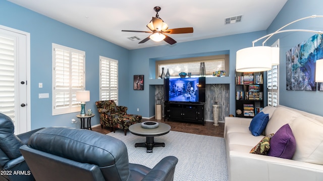 living room featuring dark wood-type flooring and ceiling fan