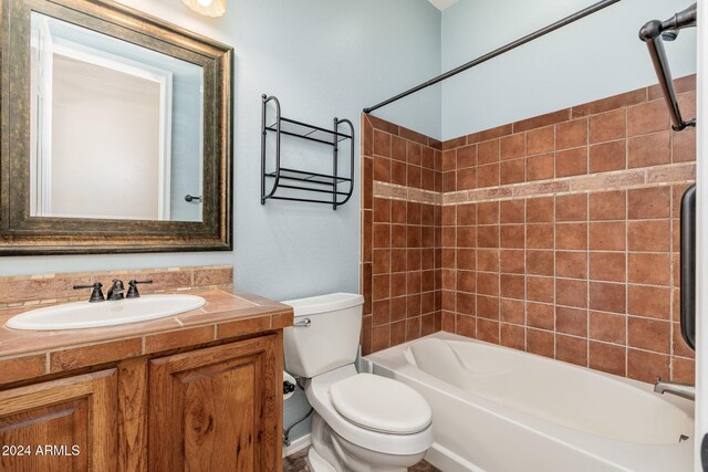 full bathroom featuring vanity, tiled shower / bath combo, and toilet