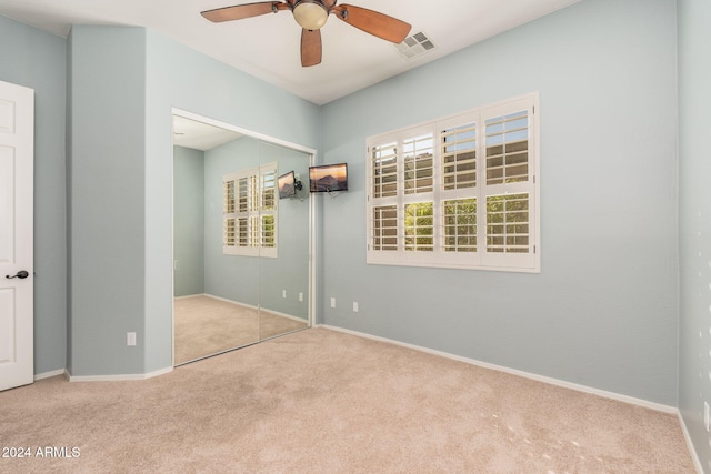 carpeted spare room featuring ceiling fan