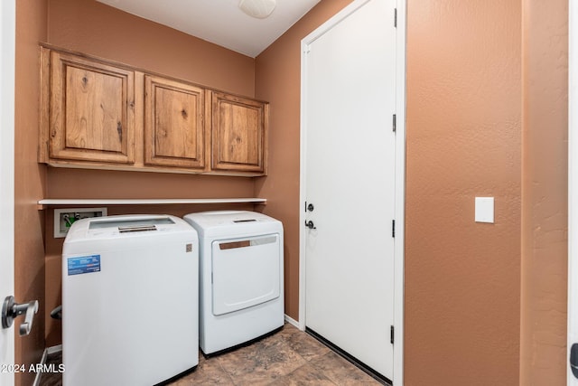 clothes washing area featuring cabinets and independent washer and dryer