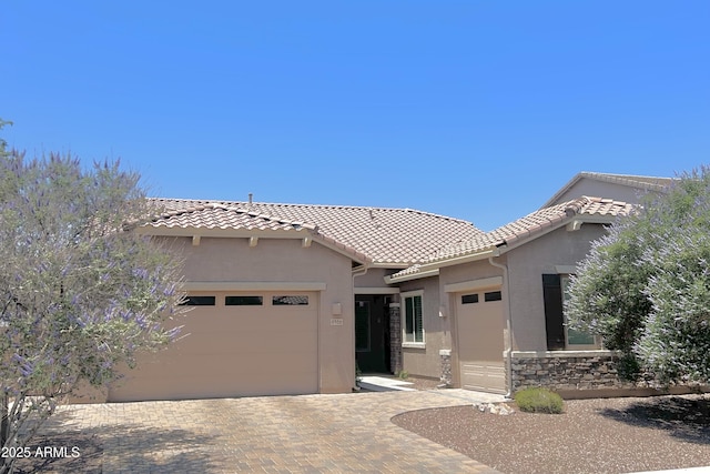 4956 S Leisure Way, Gilbert, AZ 85298 - mediterranean / spanish home featuring an attached garage, stucco siding, a tile roof, and decorative driveway