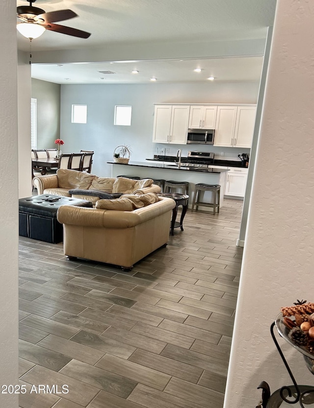 4956 S Leisure Way, Gilbert, AZ 85298 - living area featuring wood tiled floors, recessed lighting, ceiling fan, and a textured wall