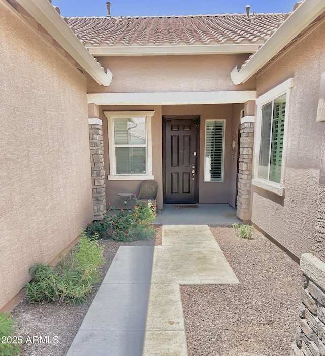 4956 S Leisure Way, Gilbert, AZ 85298 - view of exterior entry with stucco siding, a tiled roof, and stone siding