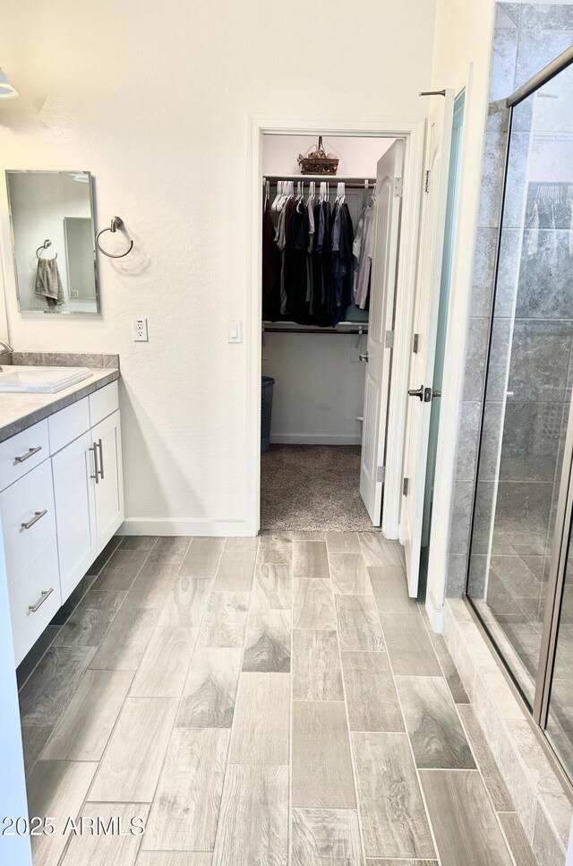 4956 S Leisure Way, Gilbert, AZ 85298 - full bath featuring vanity, a walk in closet, wood tiled floors, and a stall shower