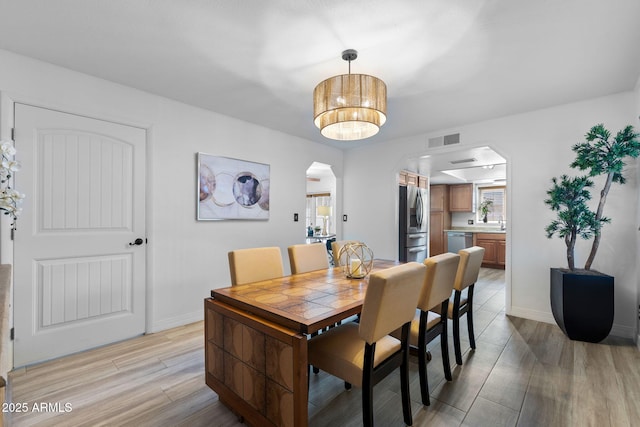 2804 N Nebraska St, Chandler, AZ 85225 - dining space with arched walkways, light wood finished floors, and baseboards