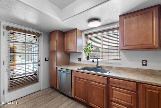 2804 N Nebraska St, Chandler, AZ 85225 - kitchen with stainless steel dishwasher, a sink, light wood-style floors, brown cabinets, and light countertops