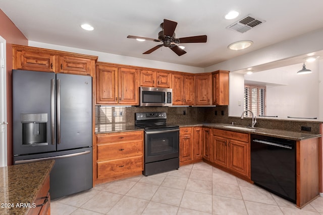 kitchen with dark stone countertops, black appliances, sink, and decorative backsplash