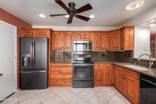 kitchen featuring decorative backsplash, ceiling fan, dark stone countertops, black appliances, and sink