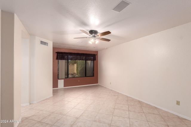 empty room featuring a textured ceiling and ceiling fan